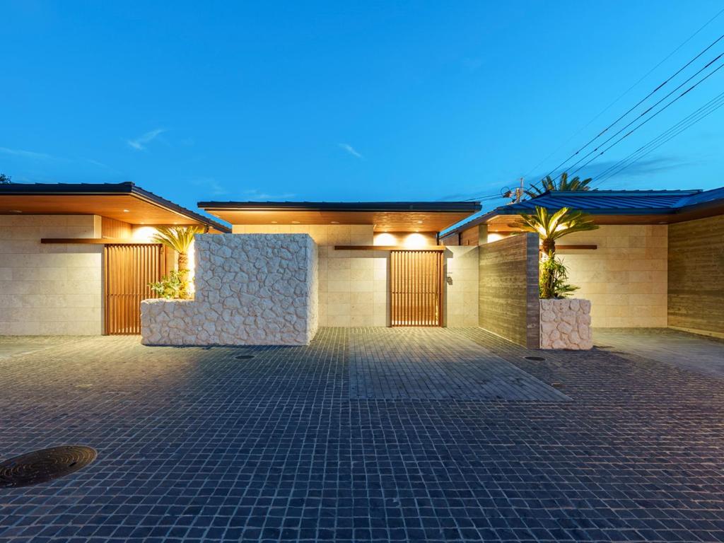 a building with a parking lot with palm trees at Tanegashima Araki Bekkan in Nishinoomote