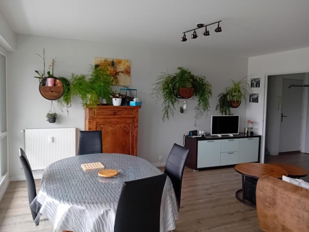 a dining room with a table and some plants at Joli appartement bien situé pour les JO in Les Essarts-le-Roi