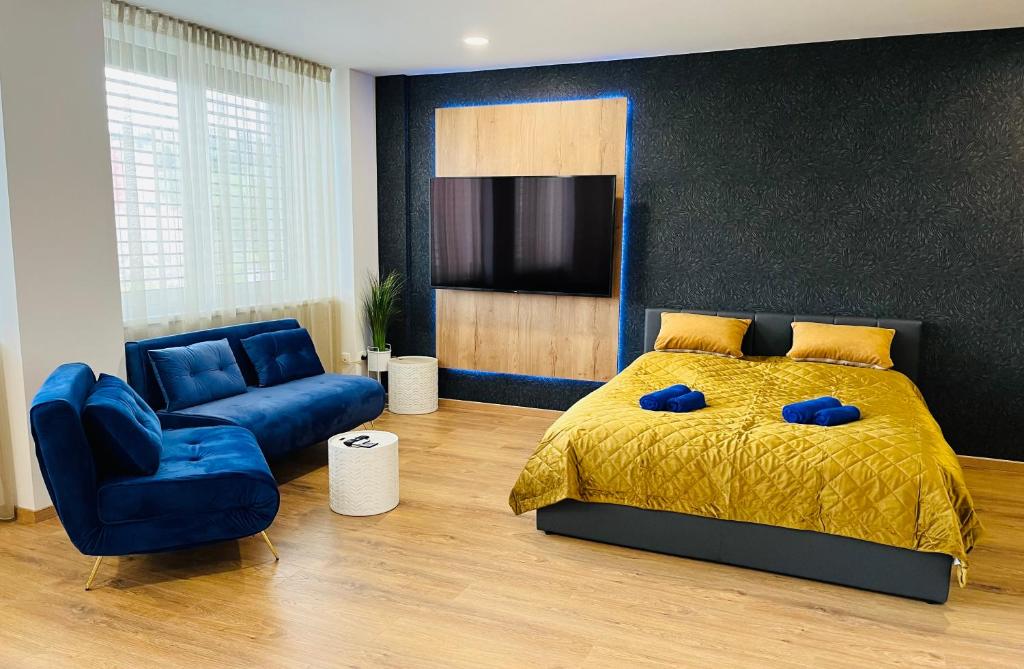 een slaapkamer met een bed en een blauwe stoel bij Apartmán Sitka in Trenčín