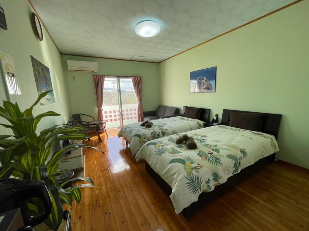 名户NAGO Sakura Resort Inn - Vacation STAY 14447v的一间卧室设有两张床和盆栽植物