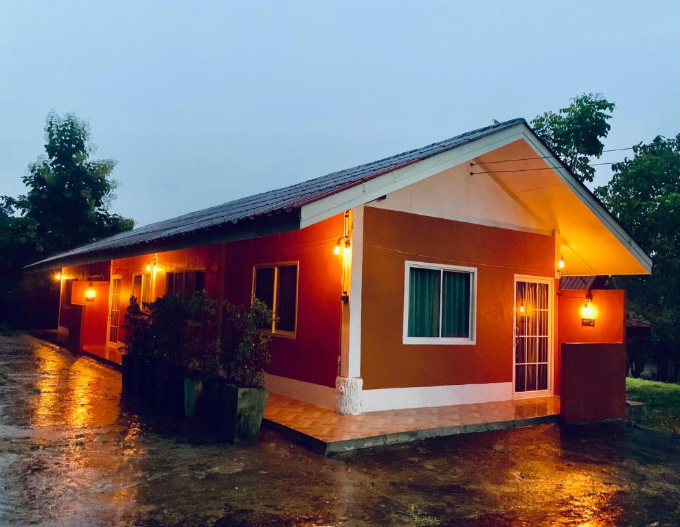 a small house in the rain with lights on at Ban Sam Bai Thao 