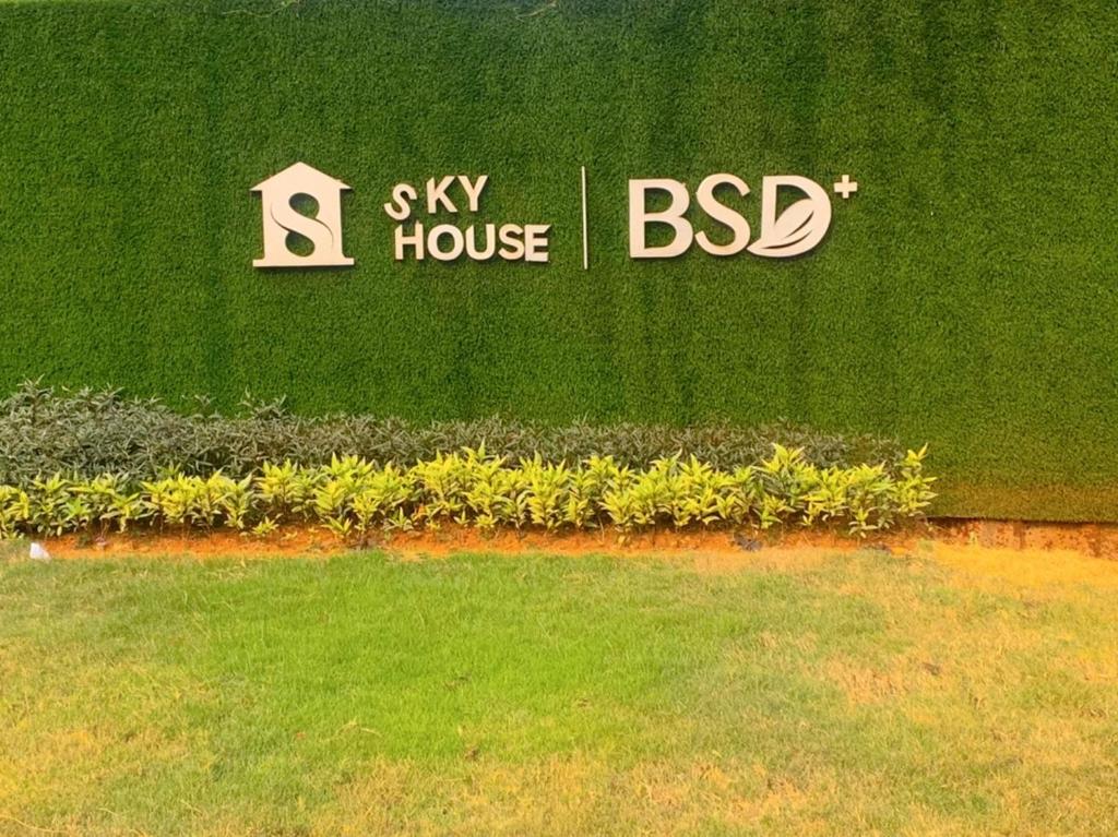 a sign for a sky house and bd signs on the grass at Apartemen Sky House BSD by Benchmark in Tangerang