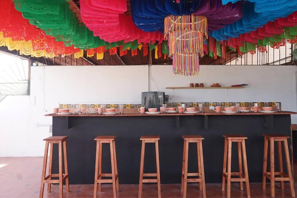 um bar com bancos num quarto com decorações coloridas em Casa Corazón em Oaxaca de Juárez