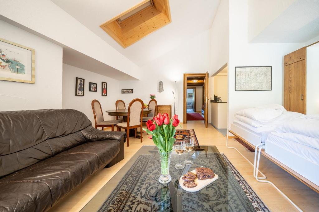 ein Wohnzimmer mit einem Sofa und einem Tisch in der Unterkunft 2403 Charmante Dachwohnung mit hohen Decken und Suedbalkon in Vulpera