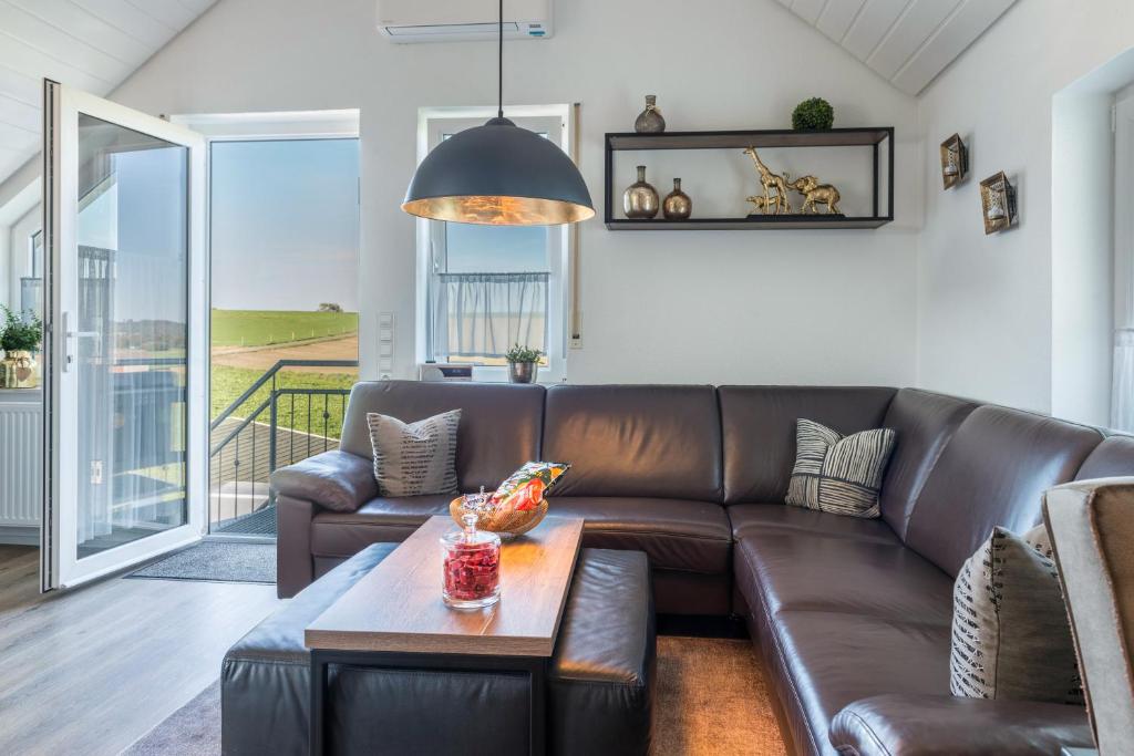 a living room with a brown leather couch and a table at Ferienwohnung Romanas in Ostrach