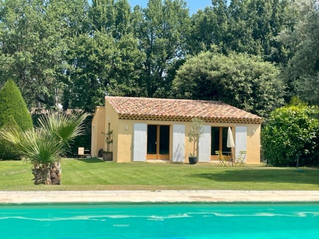 una pequeña casa junto a una piscina de agua en Charmante maisonnette avec jardin et piscine en Aix-en-Provence