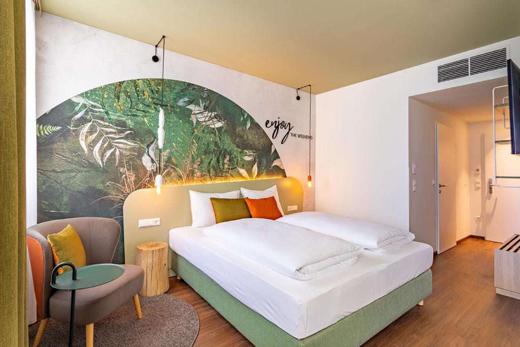 um quarto com uma cama grande e uma pintura na parede em The Weekend Hotel em Viena