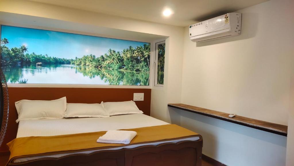 a bed in a room with a painting on the wall at Ambadi's villa -Lake view resort in Pallipuram
