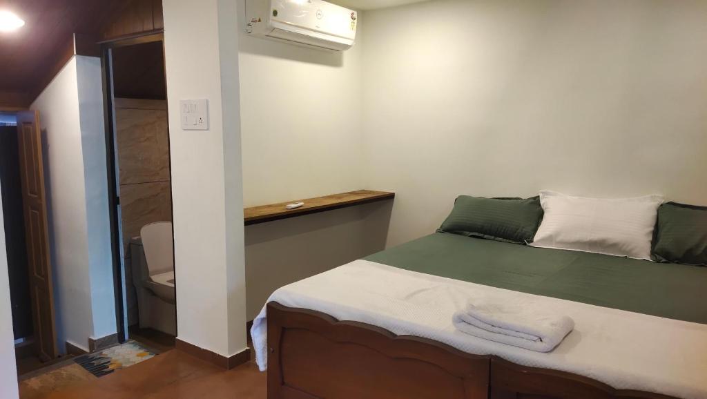 a small bedroom with a bed and a shower at Ambadi's villa -Lake view resort in Pallipuram