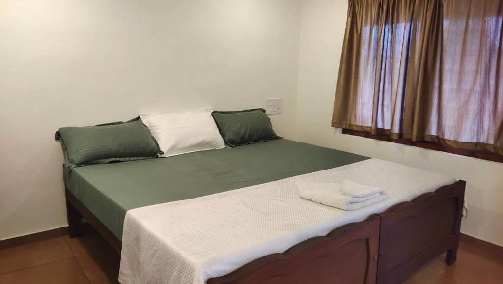 a bed with two towels on it in a room at Ambadi's villa -Lake view resort in Pallipuram
