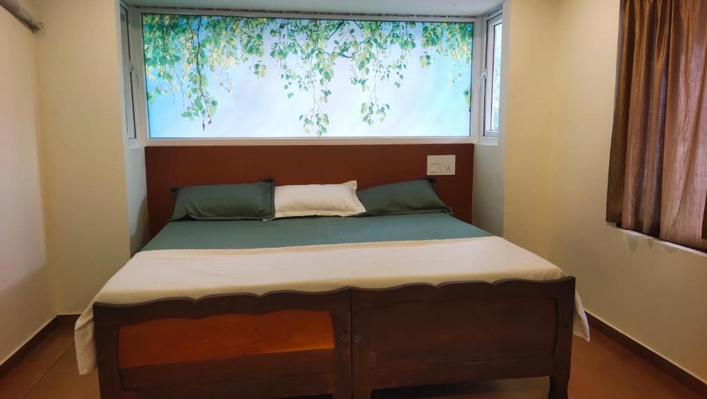 a small bed in a room with a large window at Ambadi's villa -Lake view resort in Pallipuram