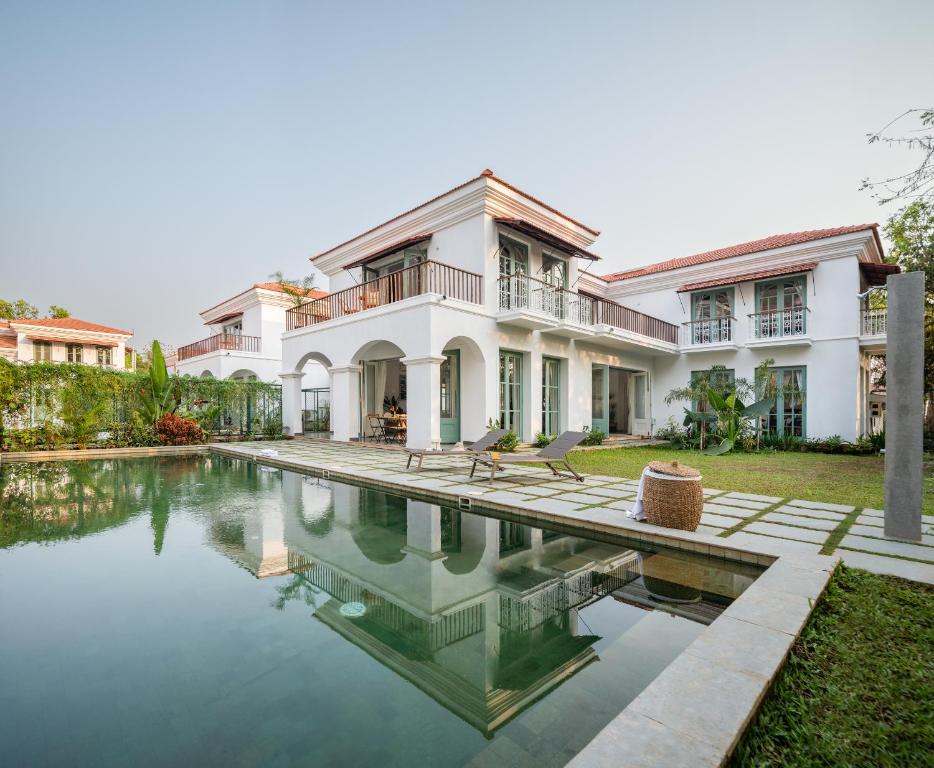 a house with a swimming pool in front of it at La Mosteiro in Assagao, Splendid 3&4BHk Villas with Private Pool, Private Parking, Garden, Caretaker, Kitchen & Security in Vagator