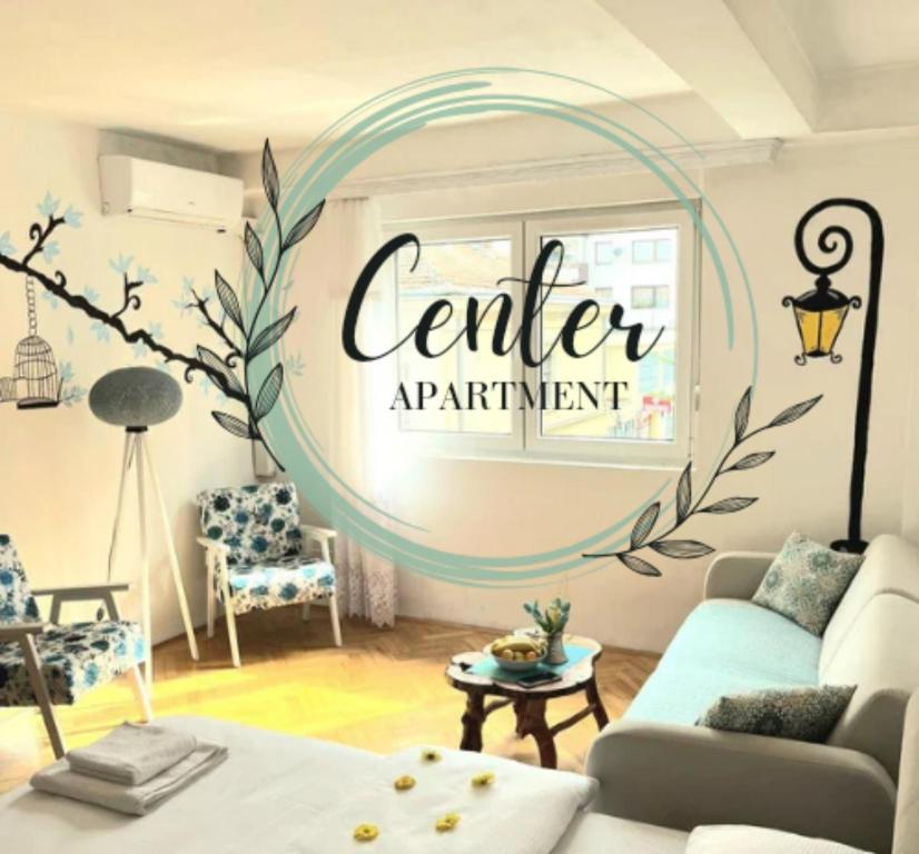 a living room with a center apartment sign on the wall at Center Apartment in Višegrad