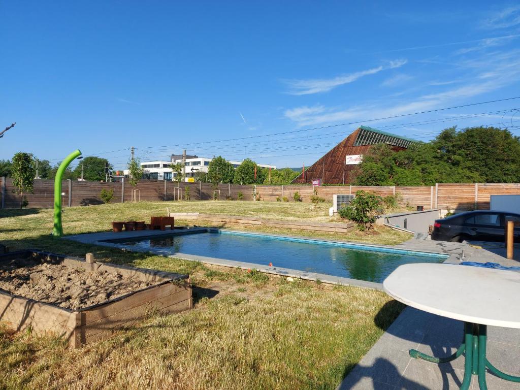 a swimming pool in a field with a table and a table at Haus Eichkogel Guntramsdorf in Guntramsdorf