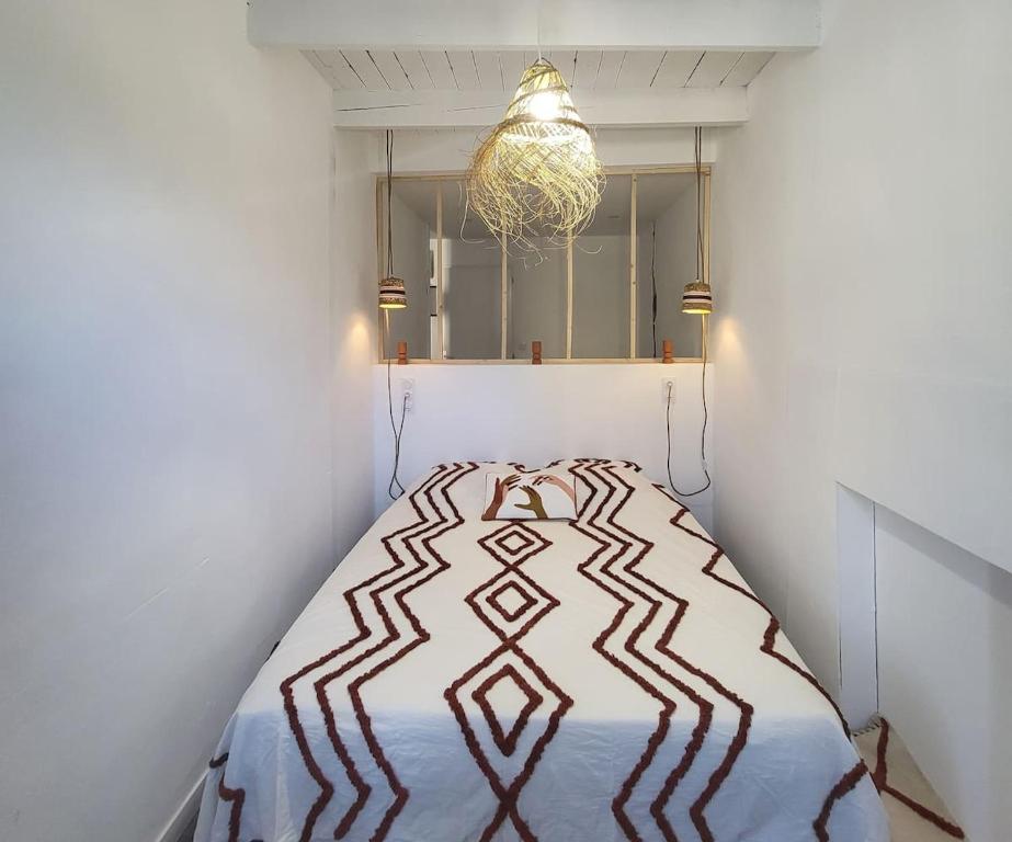 Schlafzimmer mit einem Bett und einem Kronleuchter in der Unterkunft Aux portes du Palais - garage à vélo - in Hauterives