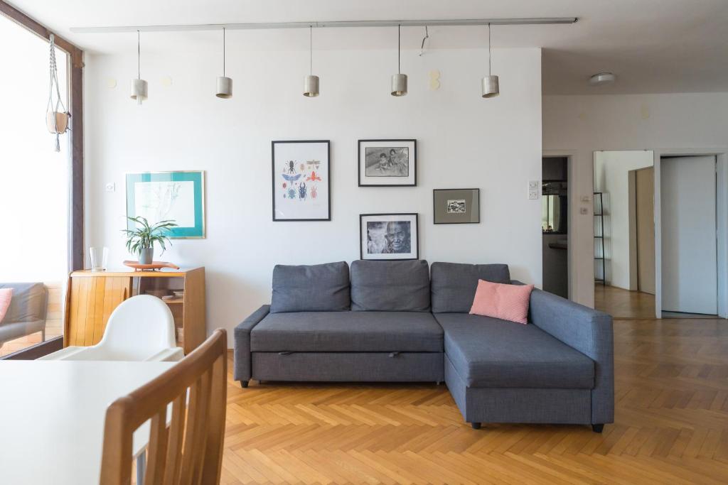 a living room with a blue couch and a table at Family apartment in the city centre - FREE parking garage in Ljubljana