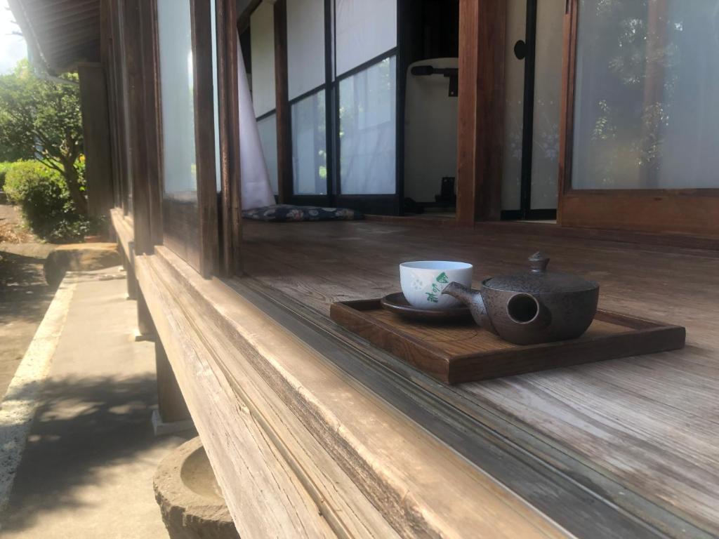 una tazza di caffè su un vassoio di legno sotto un portico di 農家民宿　佐京園 a Shimada