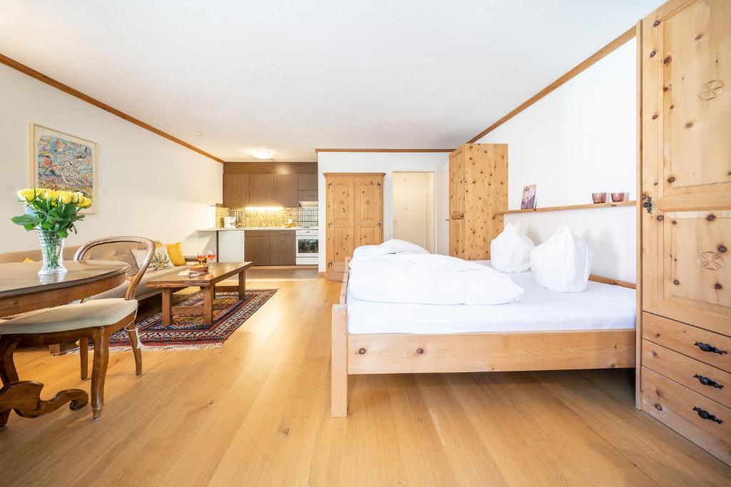 - une chambre avec un grand lit et une salle à manger dans l'établissement 3304 Preislich attraktives Studio im alpinen Stil, à Vulpera