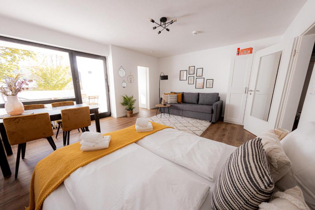 Come4Stay Passau - Apartment Seidenhof I voll ausgestattete Küche I Balkon I Badezimmer في باساو: غرفة نوم بسرير كبير وغرفة طعام