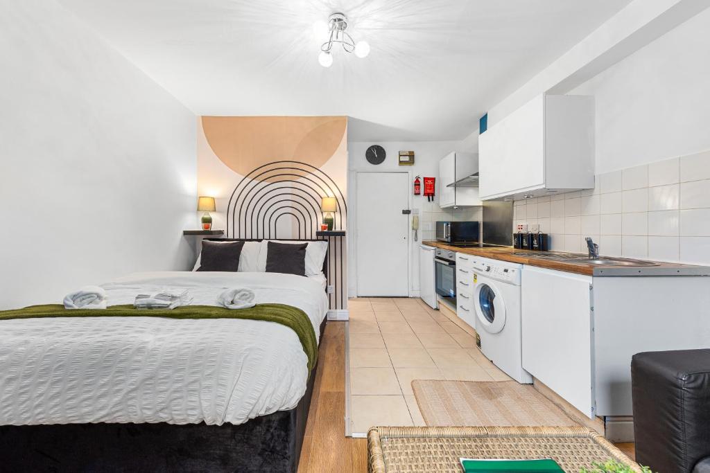 1 Schlafzimmer mit einem Bett und einer Küche in der Unterkunft Modern Gem Brixton Centre Cozy & Comfort Charis City Studio in London