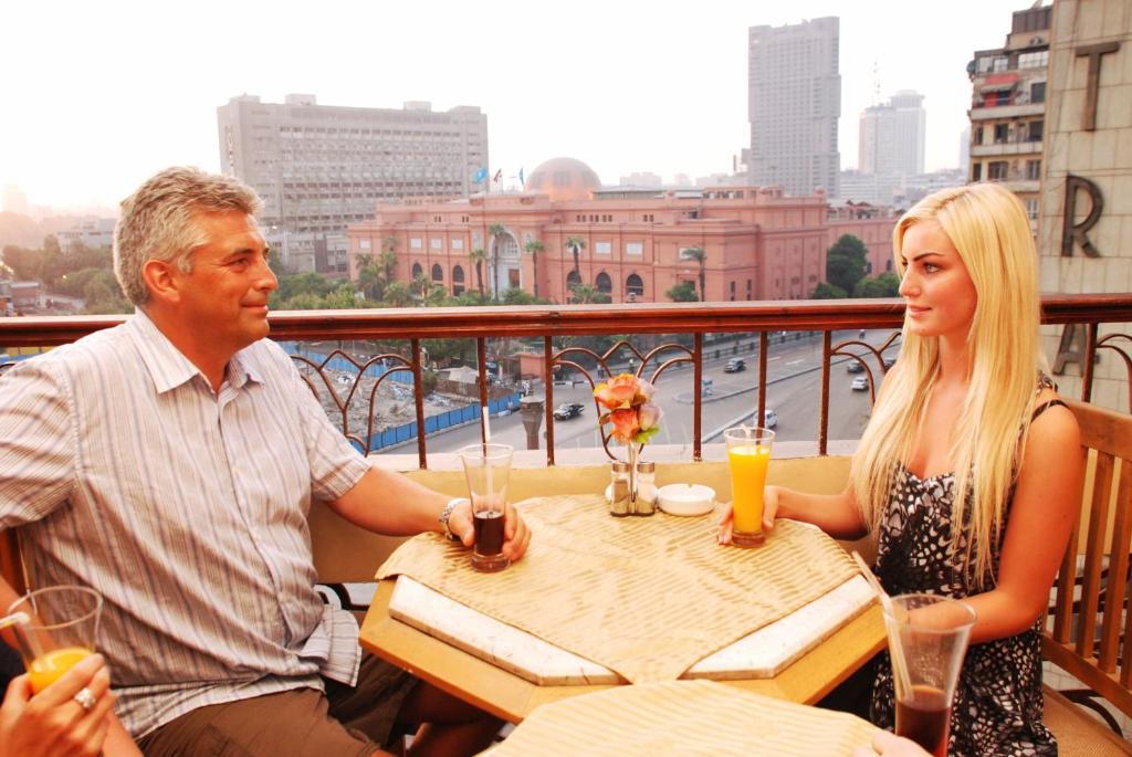 mężczyzna i kobieta siedzący przy stole na balkonie w obiekcie City View Museum Hotel w Kairze