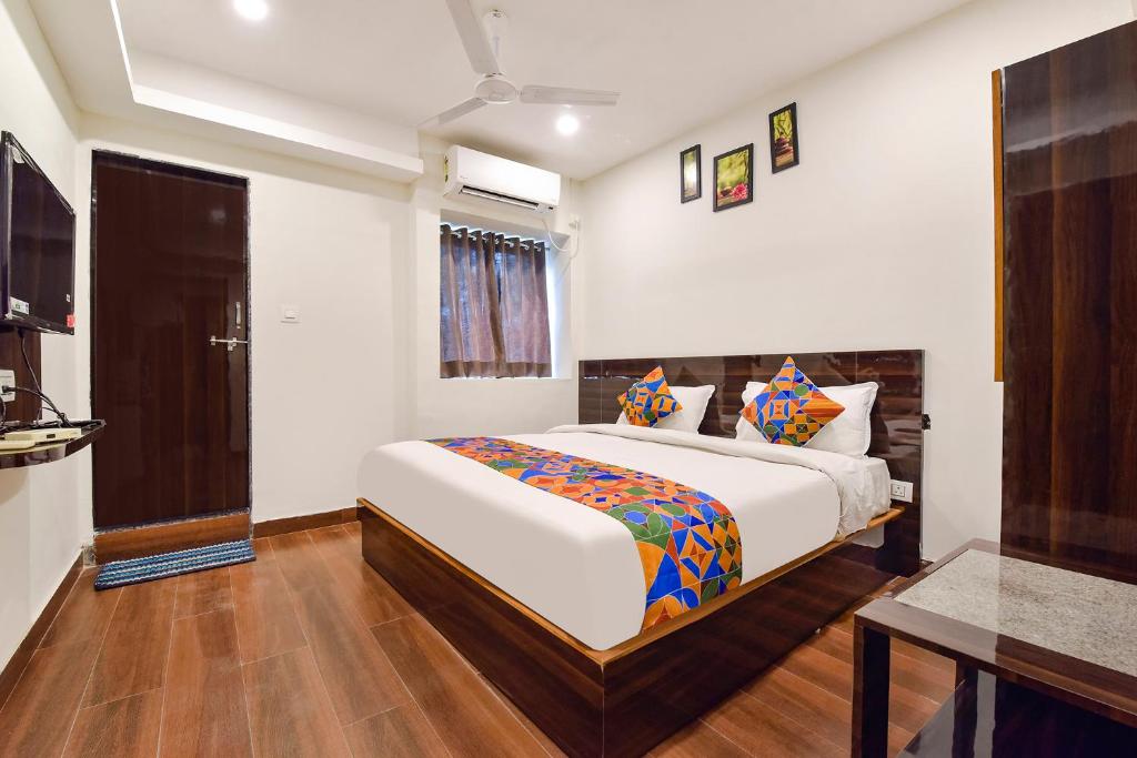 a bedroom with a large bed in a room at FabHotel Shri Krishna in Vadodara