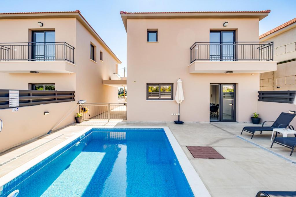 a villa with a swimming pool and a house at Villa Elpida ONE by Ezoria Villas in Timi, Paphos in Ktima