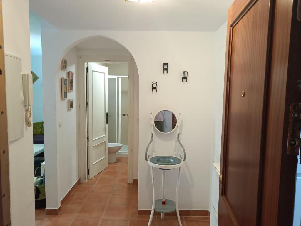 a room with a mirror and a chair in the hallway at Casa Jaime in Monachil