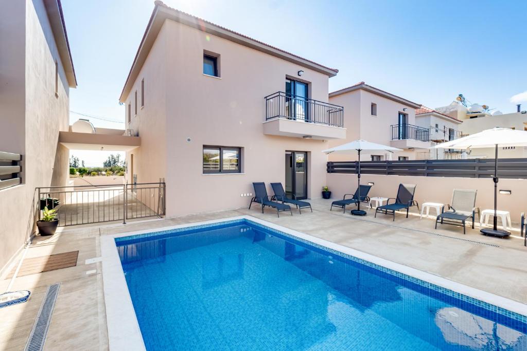 a swimming pool in the backyard of a house at Villa Elpida TWO by Ezoria Villas in Timi, Paphos in Ktima