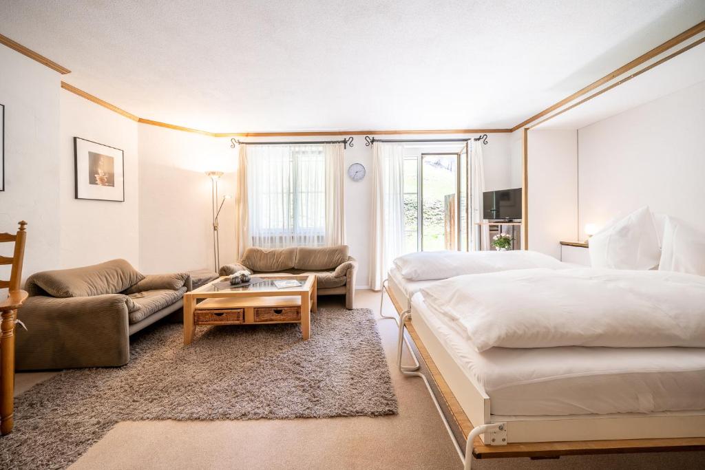 um quarto com uma cama, um sofá e uma mesa em 4103 Charmantes, neu renoviertes Studio em Vulpera