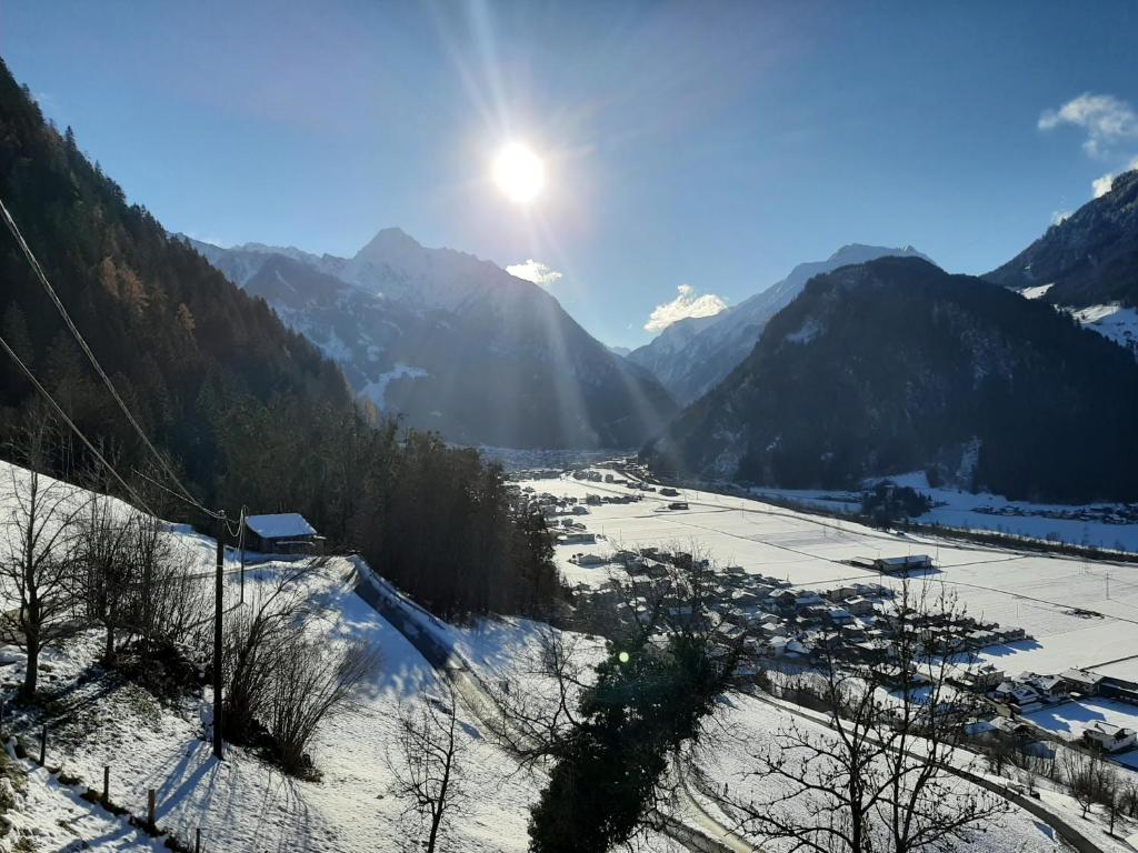 un valle cubierto de nieve con el sol en las montañas en Mountain chalet en Mayrhofen