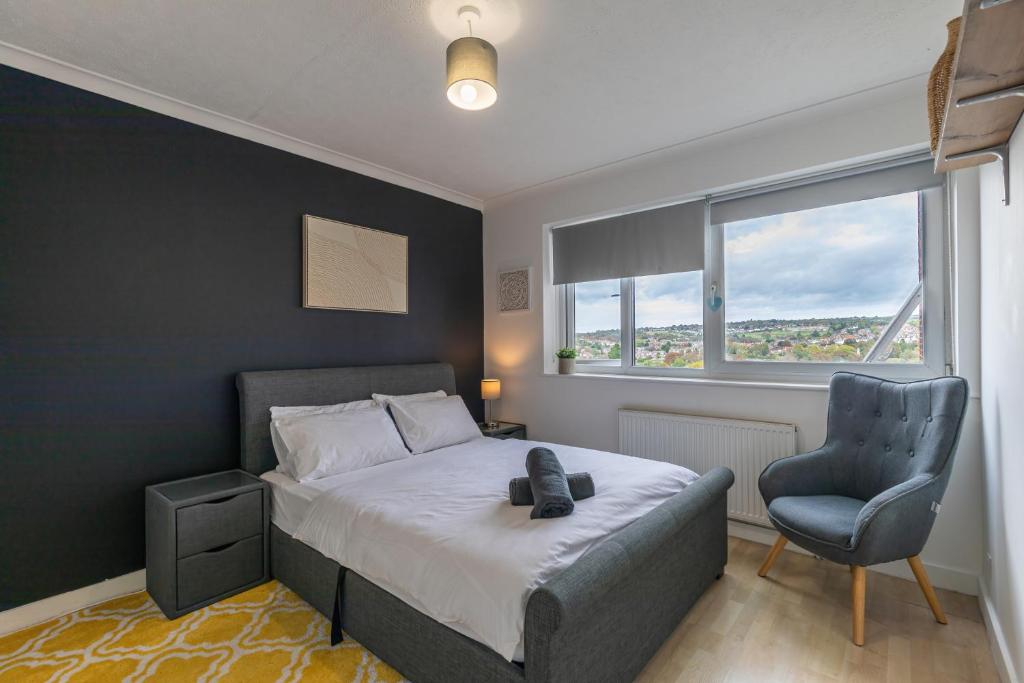 a bedroom with a bed and a chair and a window at Park View - Modern - Parking in Brighton & Hove