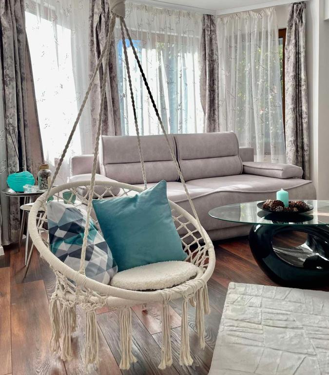 a swing chair in a living room with a couch at Si apartments Free Parking in Sofia