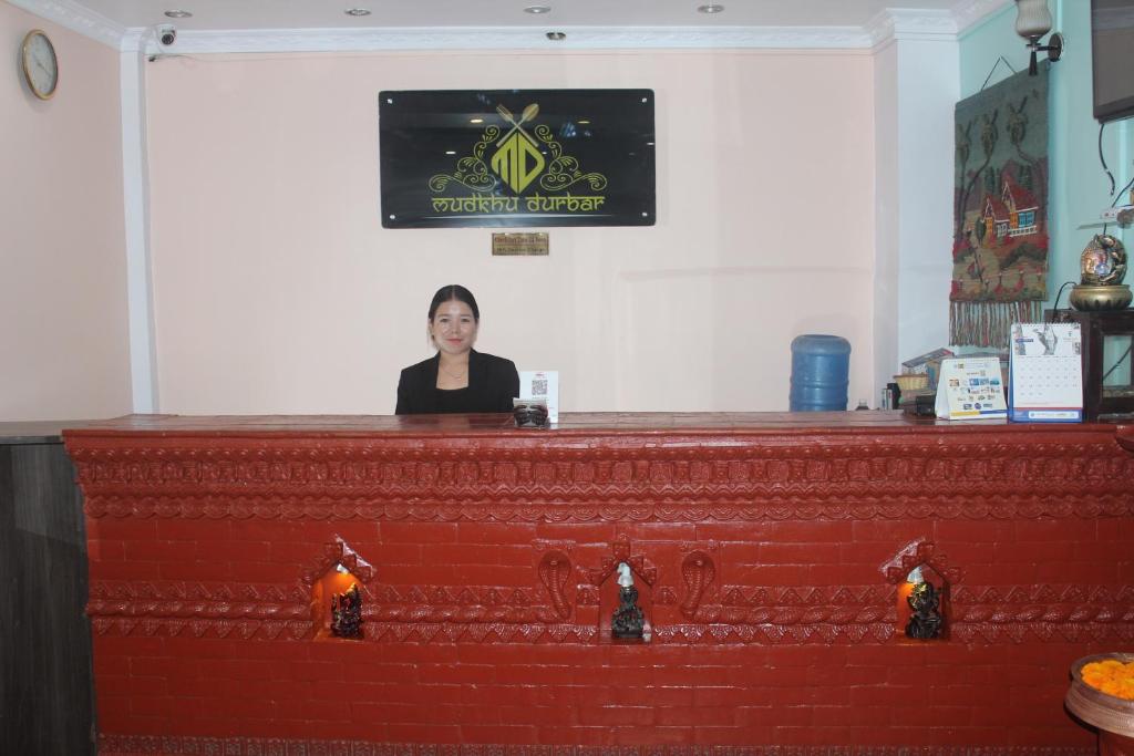 a woman standing behind a counter in a bar at Hotel Happy Home or Mudkhu Durbar in Kathmandu