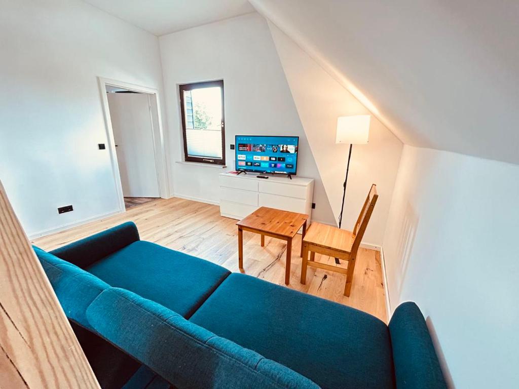 - un salon avec un canapé bleu et une table dans l'établissement Cozy Apartment near Hamburg, à Stelle