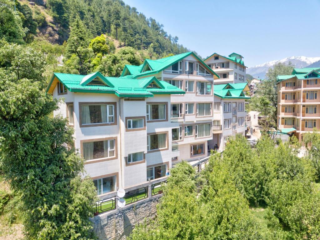 a row of apartment buildings on a hill with trees at Katson Blue Manali in Manāli