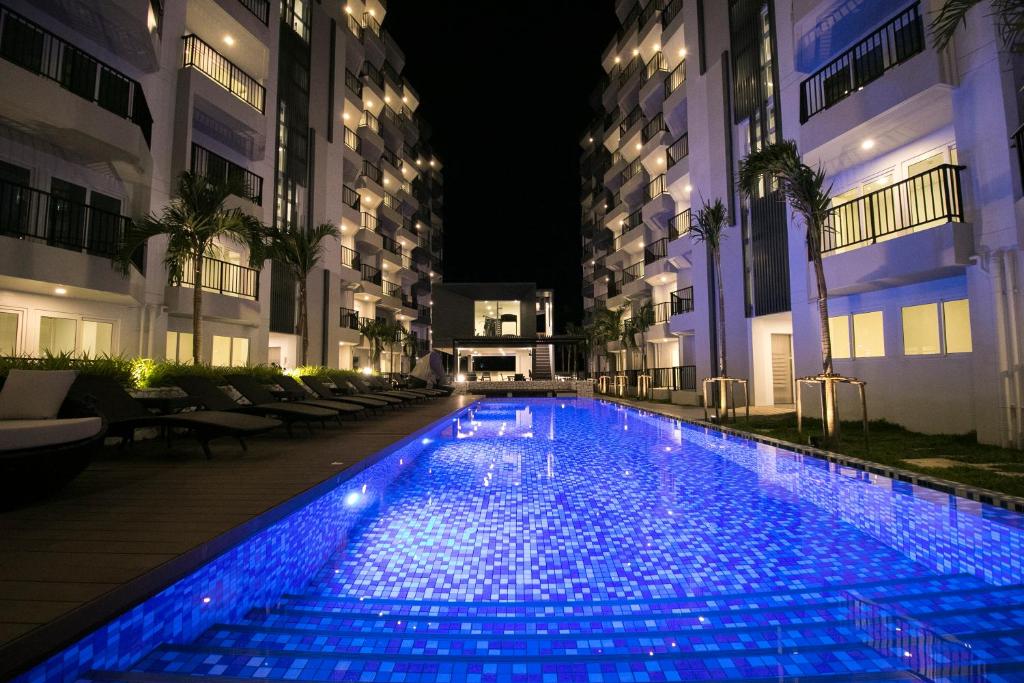 a swimming pool with blue lights in a building at Mantra Beach Condominium Suite - Mae Phim in Ban Tha Fat