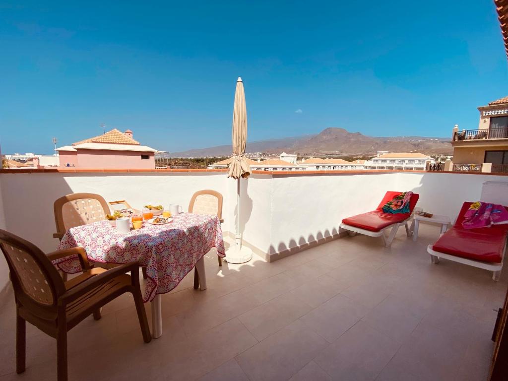 een balkon met een tafel en stoelen en uitzicht bij Moon in Playa de las Americas