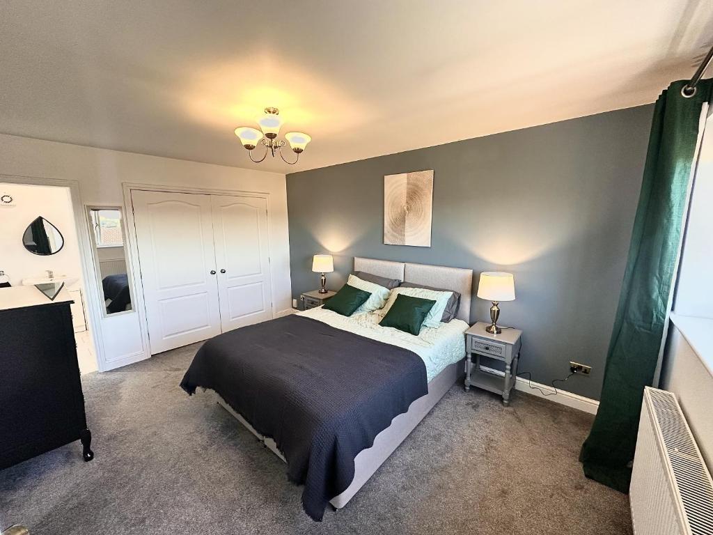 a bedroom with a large bed with green pillows at 3 Bed Home for Contractors & Relocators with Parking, Garden & WiFi 30 mins to Alton Towers in Stoke on Trent