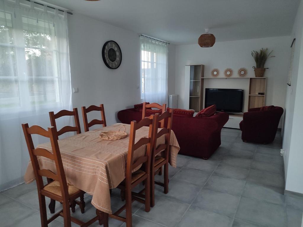 a dining room with a table and chairs and a couch at La petite maison in Mesnil-Saint-Nicaise