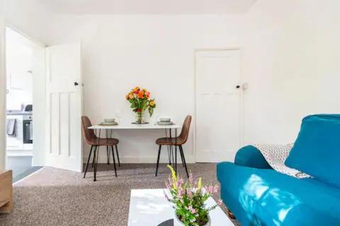a living room with a blue couch and a table at Garden Flat in central location in London