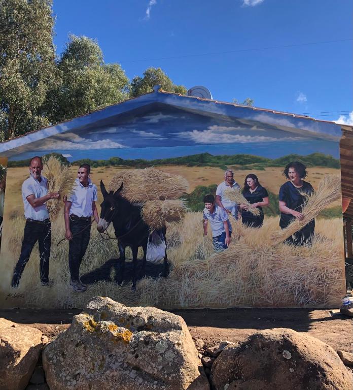 a group of people standing in front of a painting at Agriturismo S'Ispiga in Cuglieri