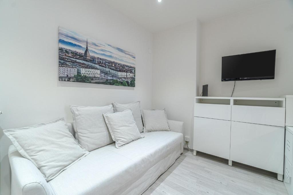uma sala de estar branca com um sofá branco e uma televisão em Crocetta District! Bright & Roomy Apartment em Turim