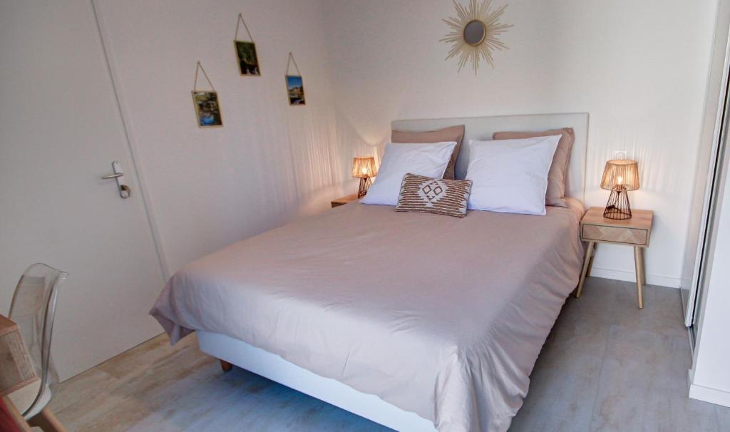 ein Schlafzimmer mit einem großen weißen Bett mit zwei Lampen in der Unterkunft Chambres d'hôtes du Val d'Asson in Montaigu-Vendée