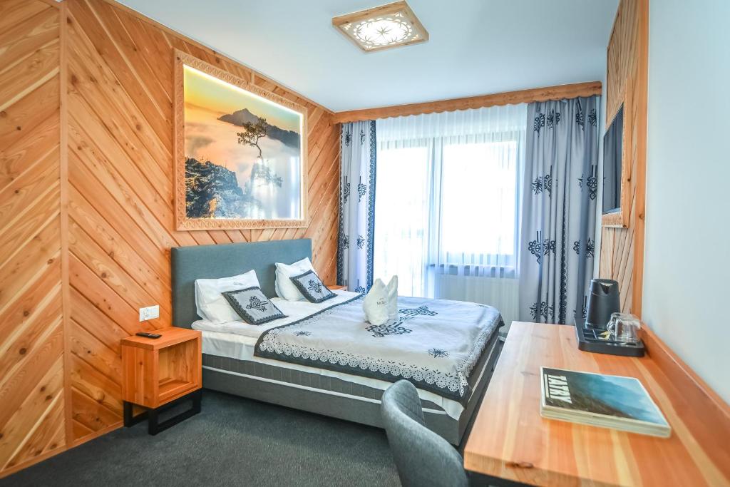 ザコパネにあるMy Tatra Residenceのベッドルーム1室(ベッド1台、テーブル、デスク付)