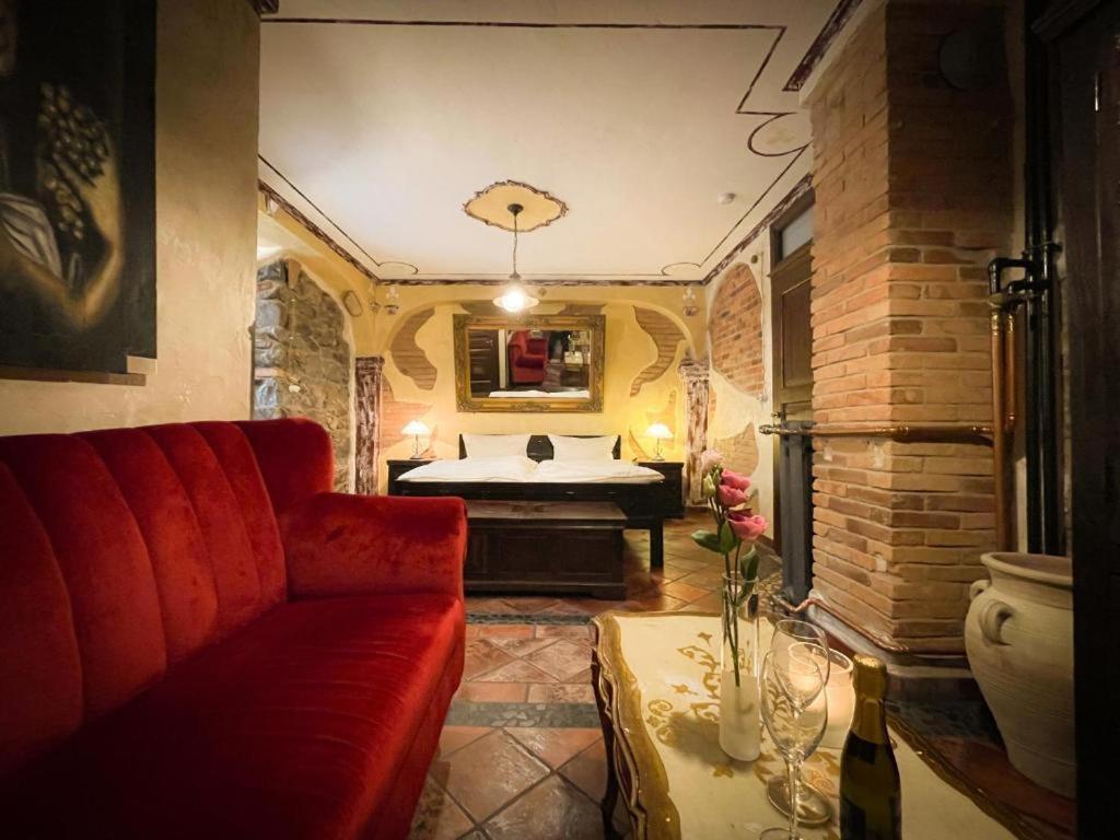 sala de estar con sofá rojo y bañera en Black Forest Hotel Todtnau, en Todtnau
