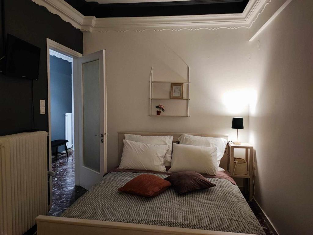 a small bedroom with a bed with white pillows at OLGAS SQUARE APARTMENT CKBSM in Patra