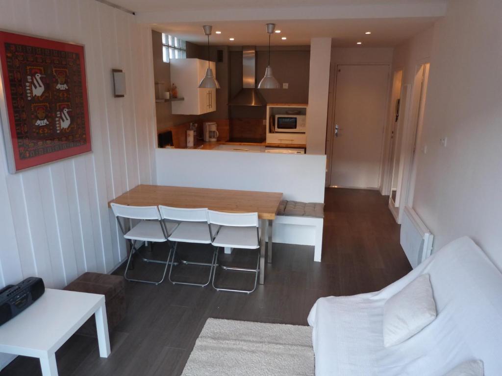 uma cozinha e sala de estar com mesa e cadeiras em Joli T2 au coeur de Praloup 1600 em Uvernet