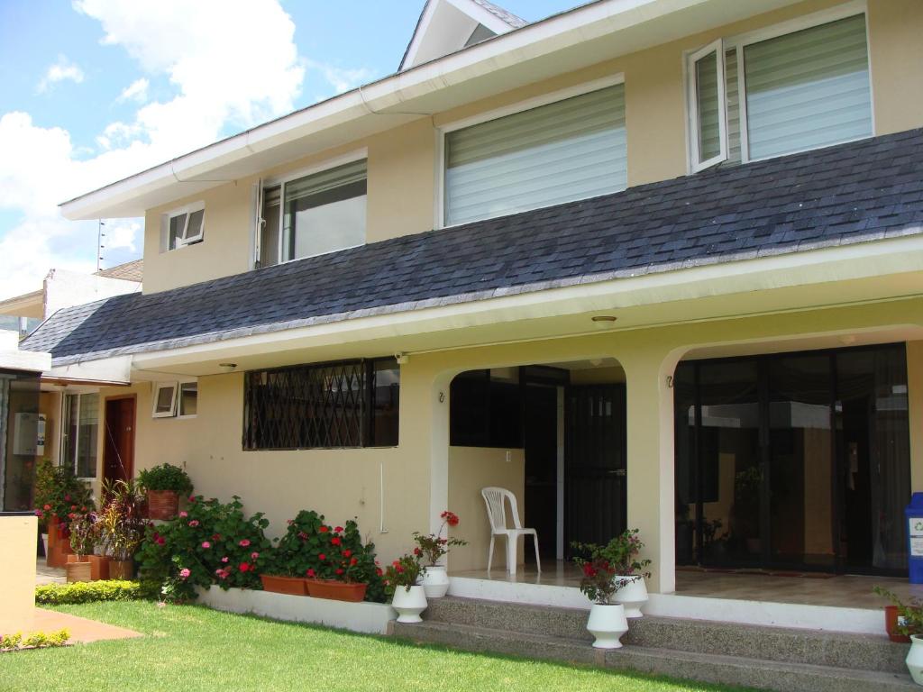 a house with large windows and a lawn at Hotel Sumaq Kay in Cumbayá