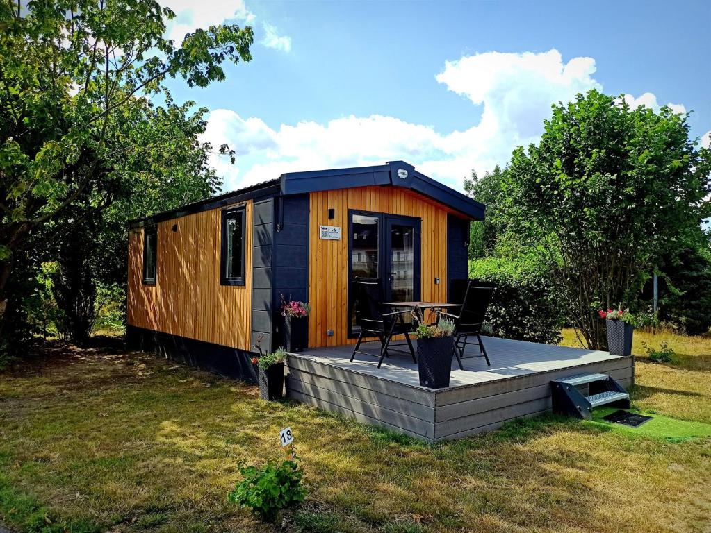 a tiny house with a deck in a yard at Tiny Haus 13 in Nabburg
